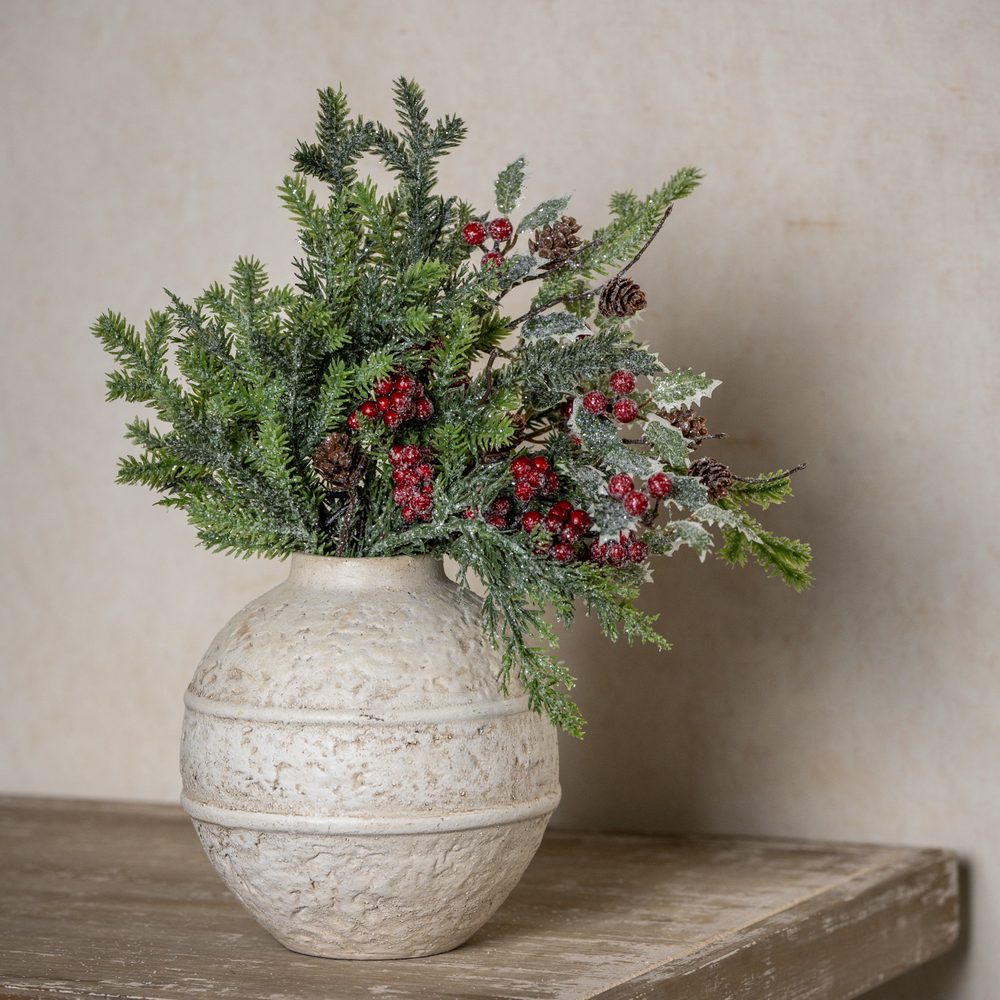 Glittered cypress, holly and red berry pick in a white textured vase
